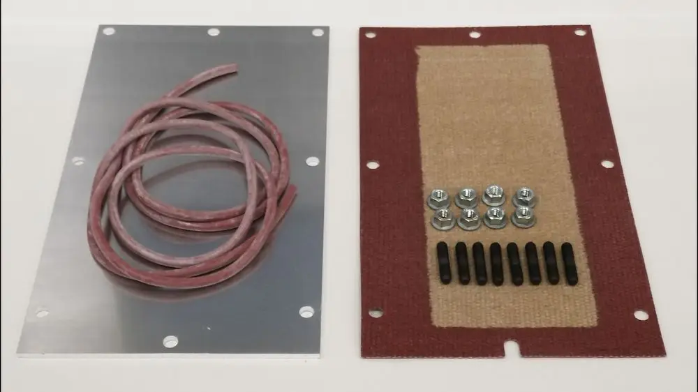 Zwei Komponenten für einen Inspektionsdeckel: eine Aluminiumplatte mit Bohrlöchern und ein weitere Platte mit Befestigungselementen, geliefert von Remeha.